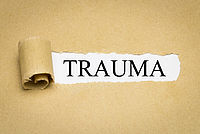 Auf der braunen Papiertafel steht das Wort „Trauma“