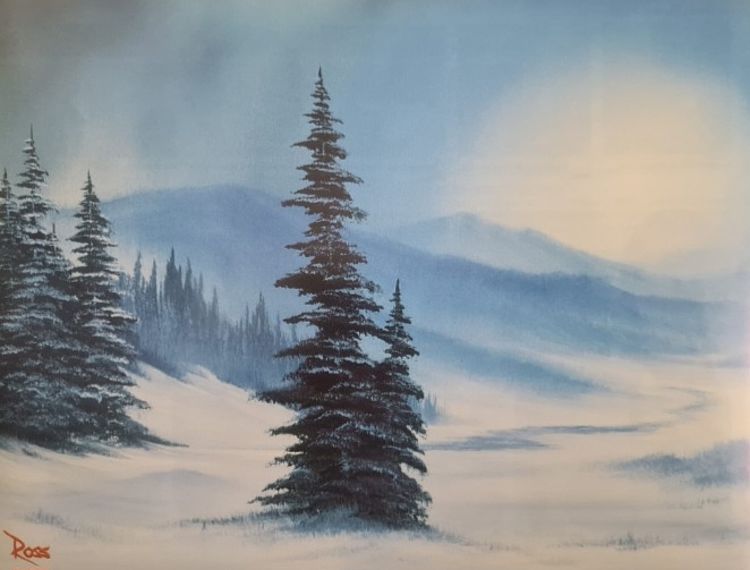 Das Bild zeigt eine winterliche Landschaft mit schneebedeckten Bergen im Hintergrund. Vor den Bergen stehen mehrere Bäume, die ebenfalls von Schnee bedeckt sind. Der Himmel wirkt düster und wolkenverhangen, was der Szene eine ruhige und etwas mystische Atmosphäre verleiht.